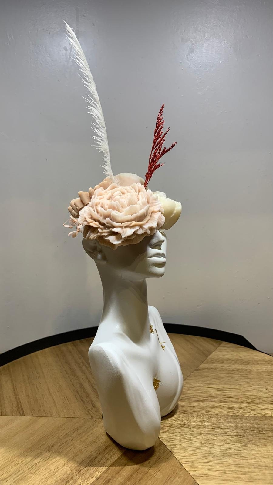 Buste en céramique blanche vu de profil, coiffé d'une pivoine de cire beige